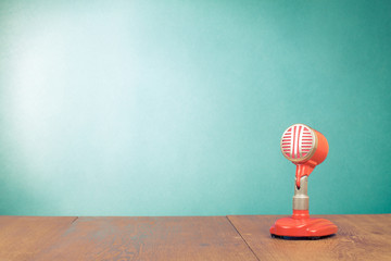 Retro red microphone on table front mint green background