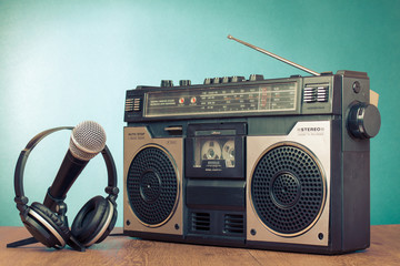 Old retro radio cassette player, headphones, microphone on table