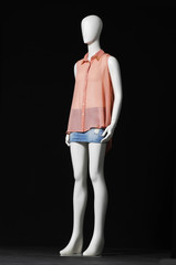 mannequin in shirt and jeans shorts-black background