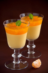 orange panna cotta with slices of oranges.