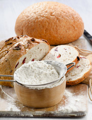 Bread and flour on wooden table.