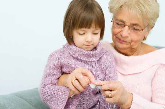 grandmother with granddaughter knitting