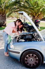 Two young and beautiful woman near the broken car