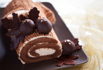 Traditional Christmas Yule Log cake with chocolate chestnuts