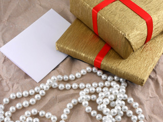 golden gift box with red bow with pearls on old paper