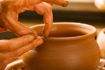 hands of a potter, creating an earthen jar
