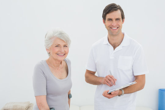 Smiling Male Therapist And Disabled Senior Patient