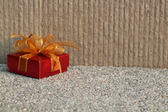 Red gift with golden ribbon on background