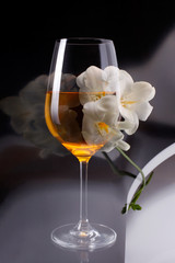 Double exposure of glass of wine over white freesia