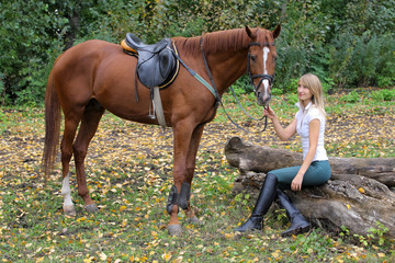 Elegant woman posing with brown racehorse
