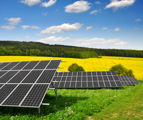 Solar energy panels against blue sky with clouds