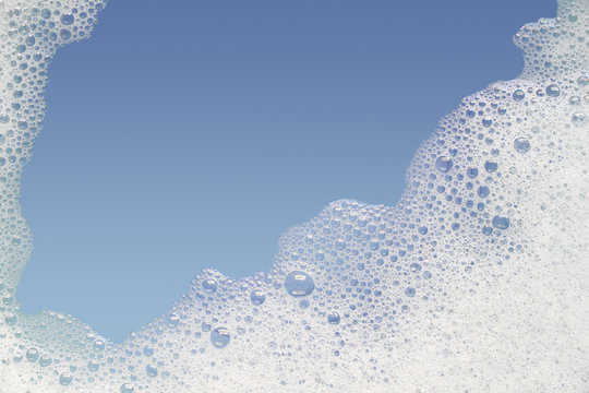 Border of bubble foam soap in blue water.