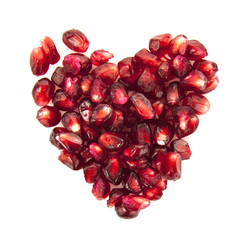 Heart of pomegranate seeds on white background