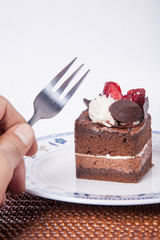 Chocolate cake with fork and strawberry