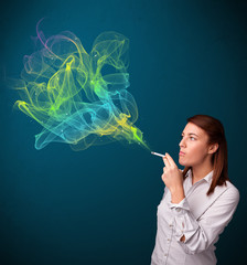Fototapeta premium Pretty lady smoking cigarette with colorful smoke
