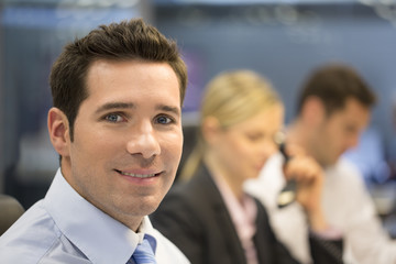 Portrait of smiling businessman in office, looking camera
