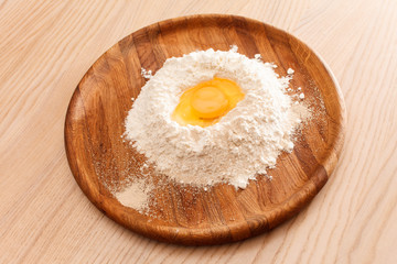 Broken egg on flour