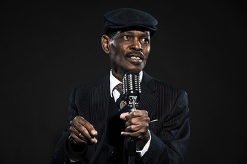 Singing retro senior afro american blues man. Wearing striped su