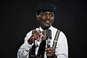 Singing retro senior afro american blues man. Wearing white shir