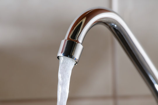 Horizontal image of a tap with water flowing normally