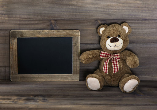 vintage style still life with teddy bear and blackboard