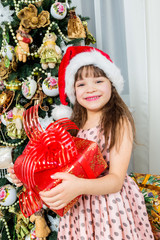 Fototapeta na wymiar Happy little girl with christmas present smiling