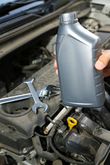 Auto mechanic hand holding motor oil