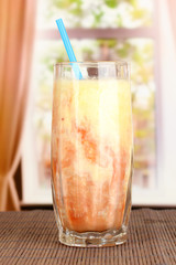 Delicious fruit smoothie on window background