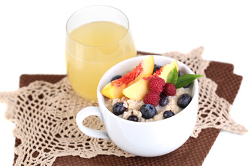 Oatmeal in cup with berries on napkins isolated on white