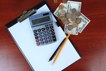 Office supplies and money on wooden background