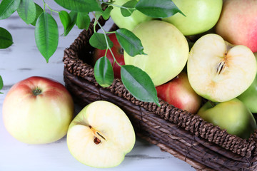 Juicy apples in basket on wooden table