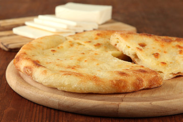 Pita breads with cheese on wooden stands close up