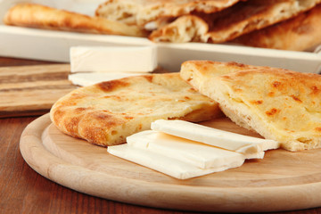 Pita breads with cheese on wooden stands close up