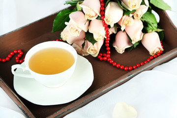 Beautiful bouquet of roses, on wooden tray, on light background