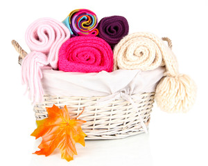 Obraz na płótnie Canvas Warm knitted scarves in basket isolated on white