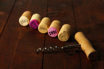 Fototapeta na wymiar Wine corks with corkscrew on wooden table close-up