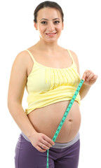 Young pregnant woman measuring her belly isolated on white