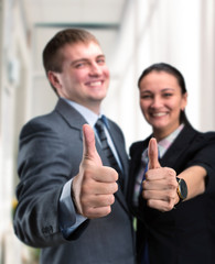 Two young happy people showing victory sign