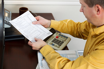 Mature Man looking at Tax Form Print Out