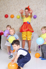 Four kids and holiday host  play with balloons