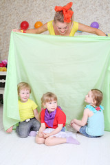 Three happy kids play with holiday host with cloth