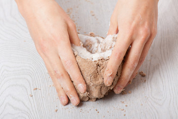 hands knead rye dough