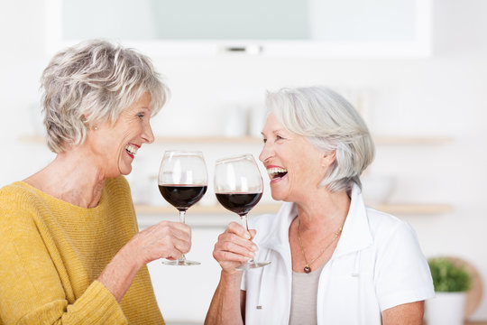 zwei seniorinnen genießen ein glas rotwein