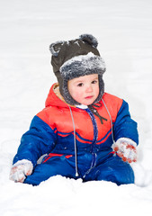 Portrait of beautiful boy sitting on the snow