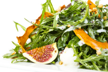 salad of arugula figs and cheese on white background