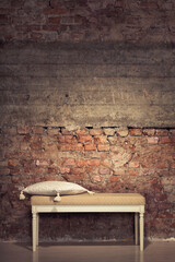 Antique chair against a grungy brick wall
