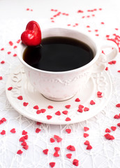 White cup of coffee decorated with red heart