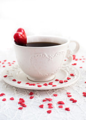 White cup of coffee decorated with red heart