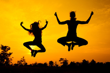 mother and  daughter jumping on the nature