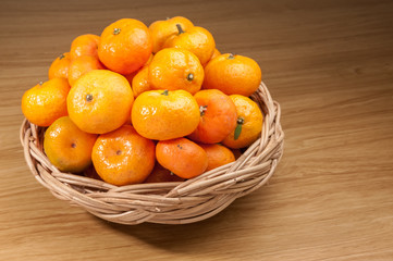 Orange fruite with basket on wood table